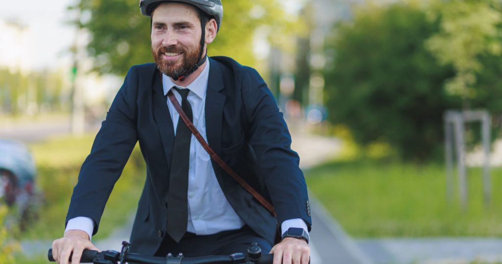 Cheerful manager wearing business apparel commuting using bicycle, Washington State Bike Laws, (https://washington.wattelandyork.com/)